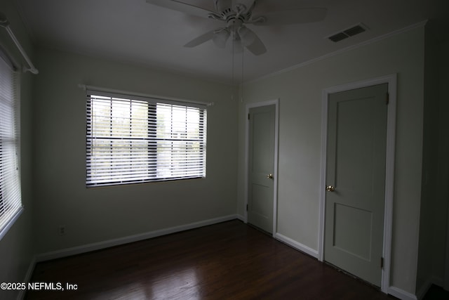 spare room with visible vents, baseboards, dark wood-type flooring, and ceiling fan