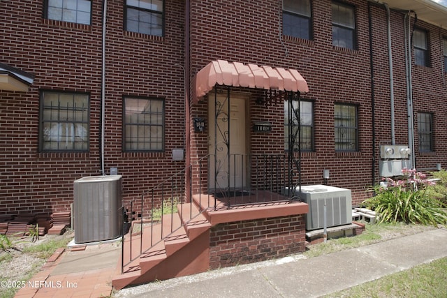 exterior space featuring central air condition unit and brick siding