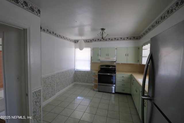 kitchen featuring light tile patterned flooring, freestanding refrigerator, stainless steel range with electric cooktop, light countertops, and under cabinet range hood