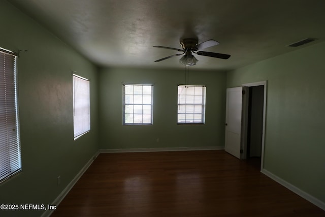 unfurnished room with visible vents, baseboards, wood finished floors, and a ceiling fan