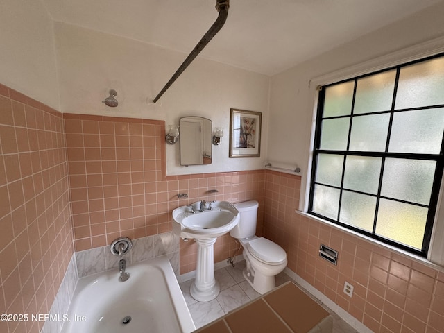 full bathroom with tile patterned flooring, toilet, tile walls, and wainscoting