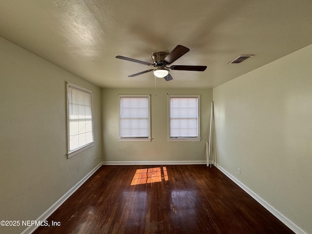 unfurnished room with baseboards, wood finished floors, visible vents, and ceiling fan