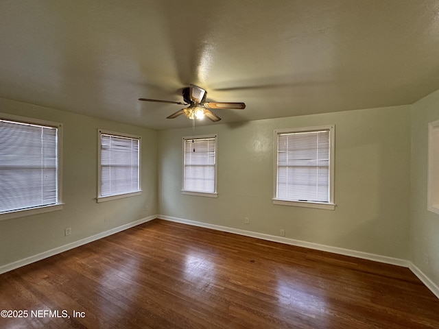 unfurnished room featuring wood finished floors, baseboards, and ceiling fan