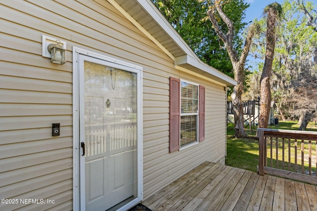 property entrance with a deck and a yard