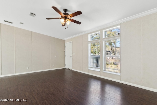 spare room with visible vents, dark wood-style floors, crown molding, baseboards, and ceiling fan