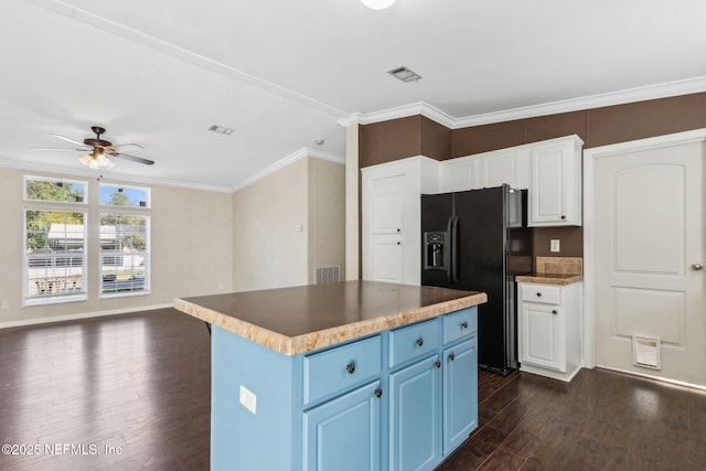 kitchen with dark wood-type flooring, ornamental molding, black fridge, blue cabinets, and a ceiling fan