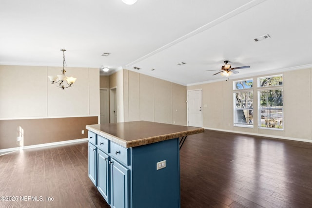 kitchen featuring blue cabinetry, crown molding, and dark wood-style flooring