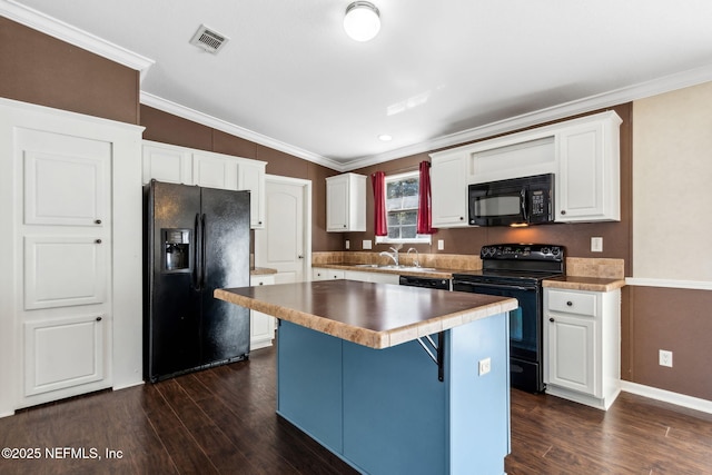 kitchen featuring visible vents, black appliances, a kitchen island, dark wood finished floors, and crown molding