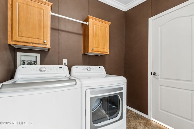 washroom with cabinet space, washing machine and dryer, and ornamental molding