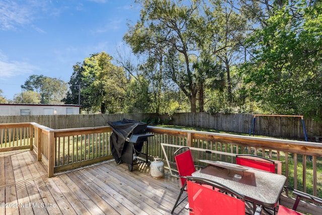 wooden terrace with a fenced backyard and grilling area