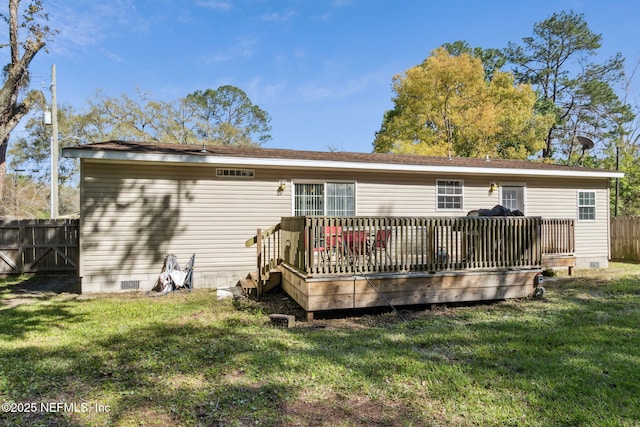 back of property featuring a yard, fence, and crawl space