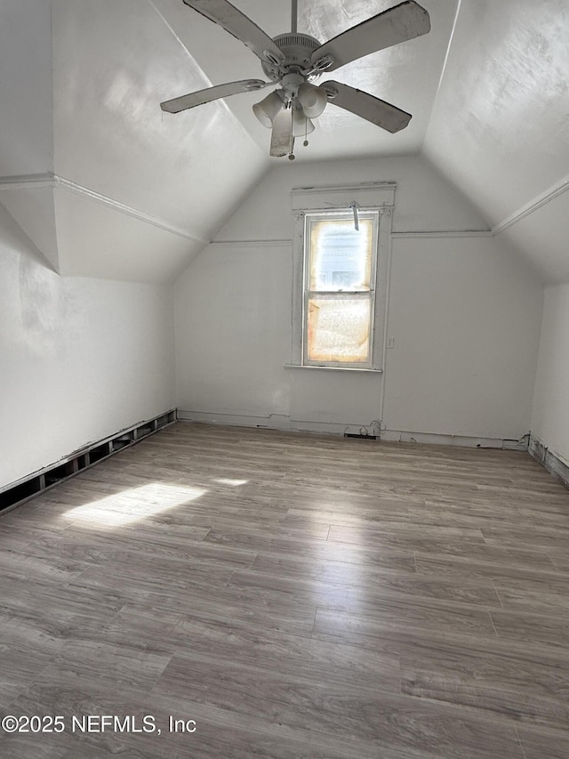 additional living space featuring a ceiling fan, lofted ceiling, and wood finished floors