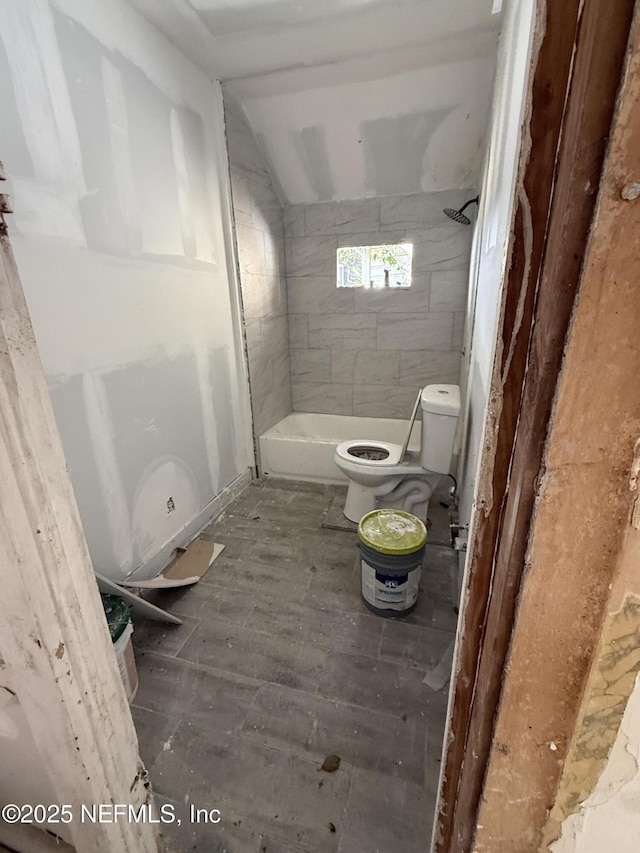 full bath with vaulted ceiling, tiled shower, toilet, and wood finished floors