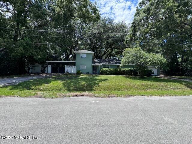 view of front of house with driveway, an attached carport, and a front lawn