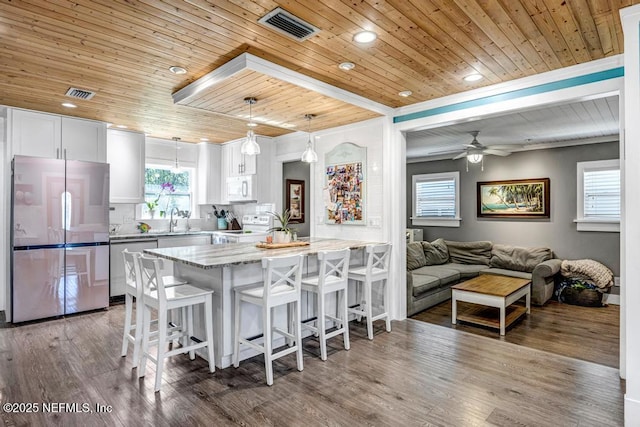 kitchen with a breakfast bar area, visible vents, appliances with stainless steel finishes, and a sink