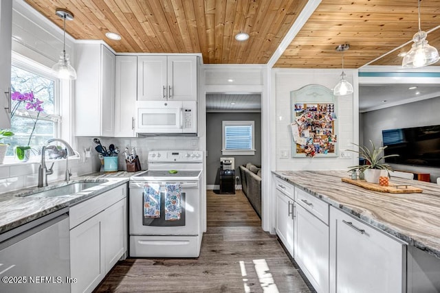 kitchen with white appliances, white cabinetry, and a sink