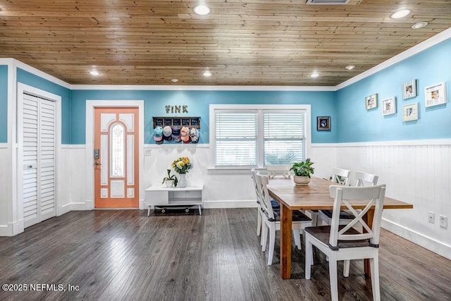 unfurnished dining area with a wainscoted wall, wooden ceiling, crown molding, and wood finished floors