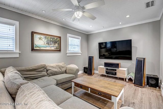 living room featuring visible vents, crown molding, light wood finished floors, baseboards, and ceiling fan