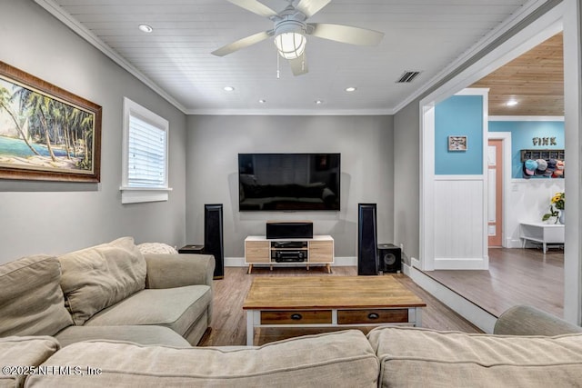 living room with crown molding, wood finished floors, visible vents, and ceiling fan