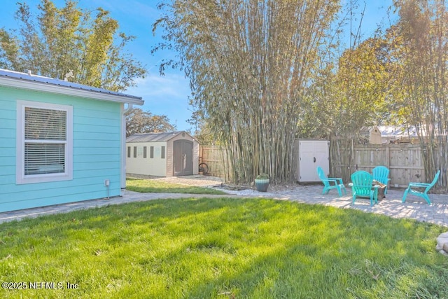 view of yard with a patio area, a storage shed, an outdoor structure, and fence