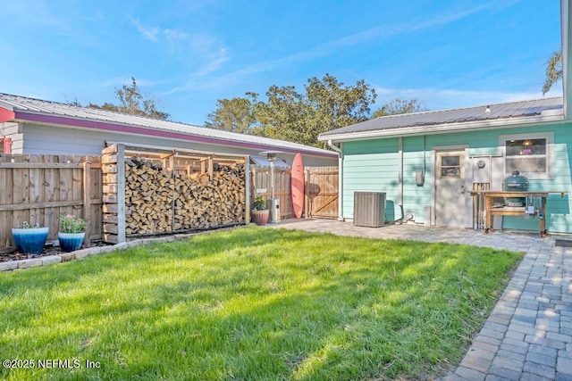 view of yard featuring a gate, fence, and central AC