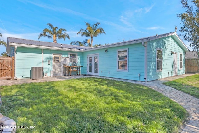 rear view of property featuring french doors, central air condition unit, a yard, and fence