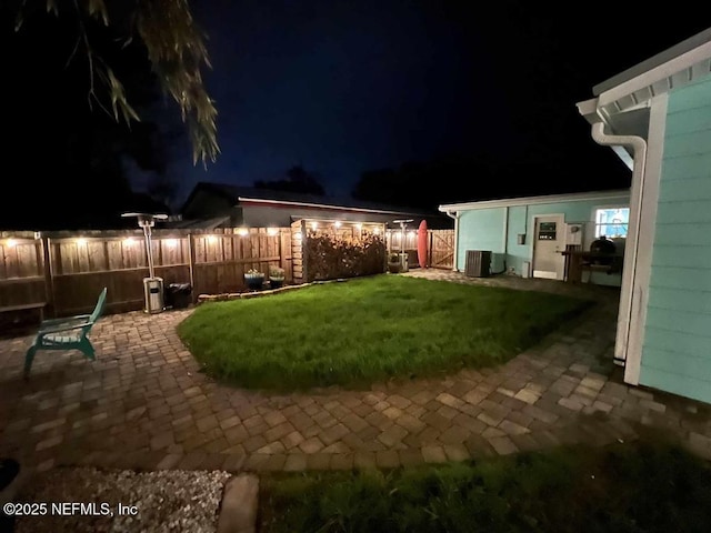 yard at twilight with a patio, cooling unit, and fence