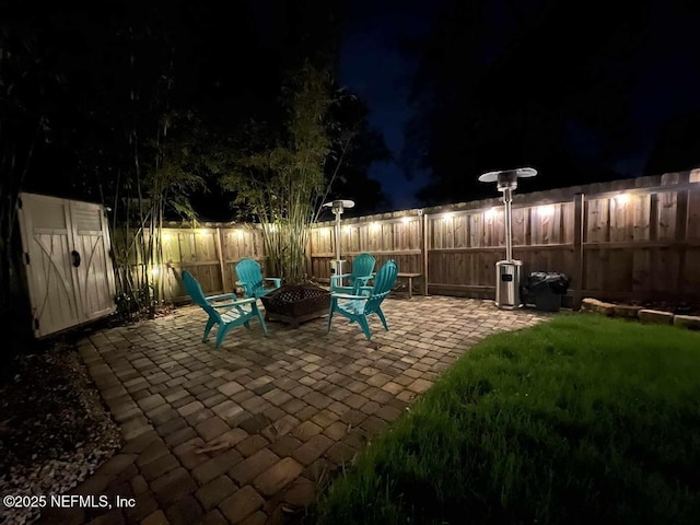 patio at twilight with fence and a fire pit