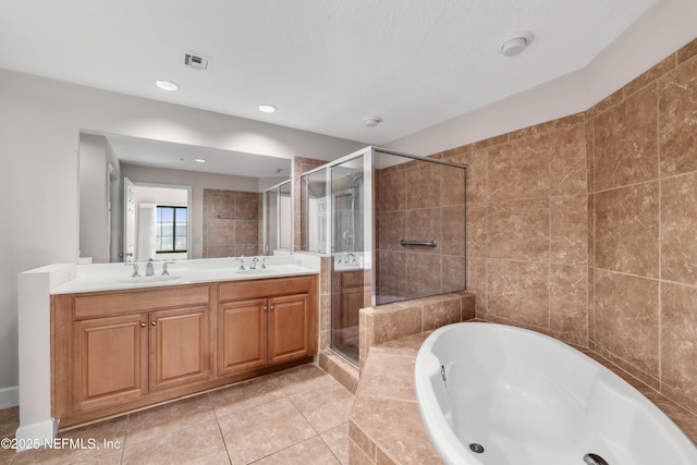 full bath with visible vents, a garden tub, double vanity, a stall shower, and a sink