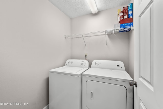 clothes washing area featuring laundry area, washing machine and dryer, and a textured ceiling