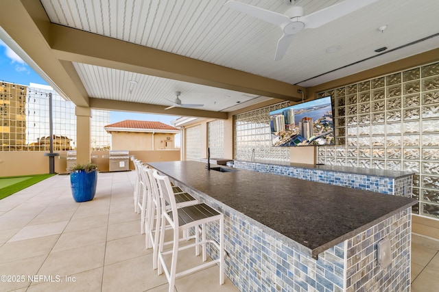 view of patio featuring ceiling fan, outdoor wet bar, and a sink