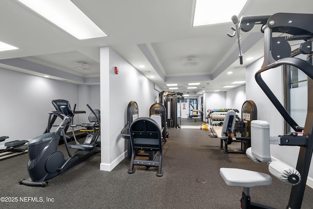 gym featuring recessed lighting, a tray ceiling, baseboards, and ornamental molding