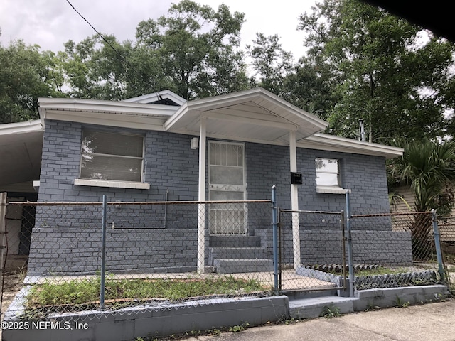 view of front facade featuring a fenced front yard, brick siding, and a gate