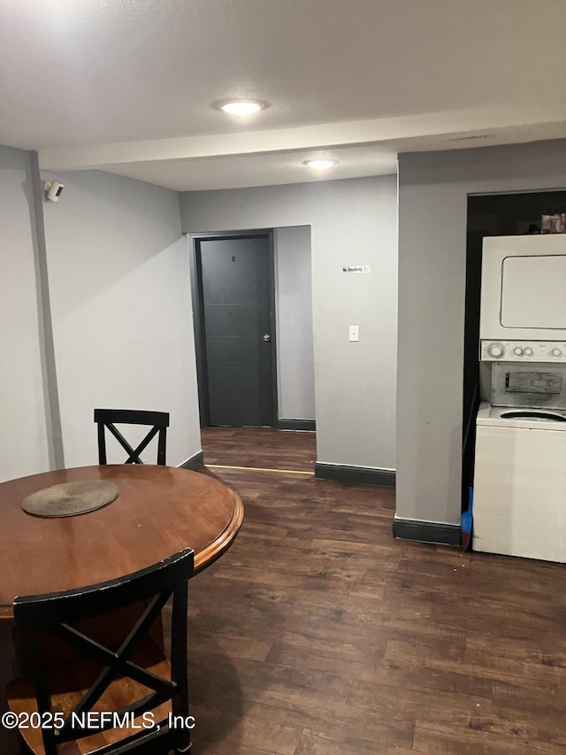 dining room with wood finished floors, baseboards, and stacked washing maching and dryer