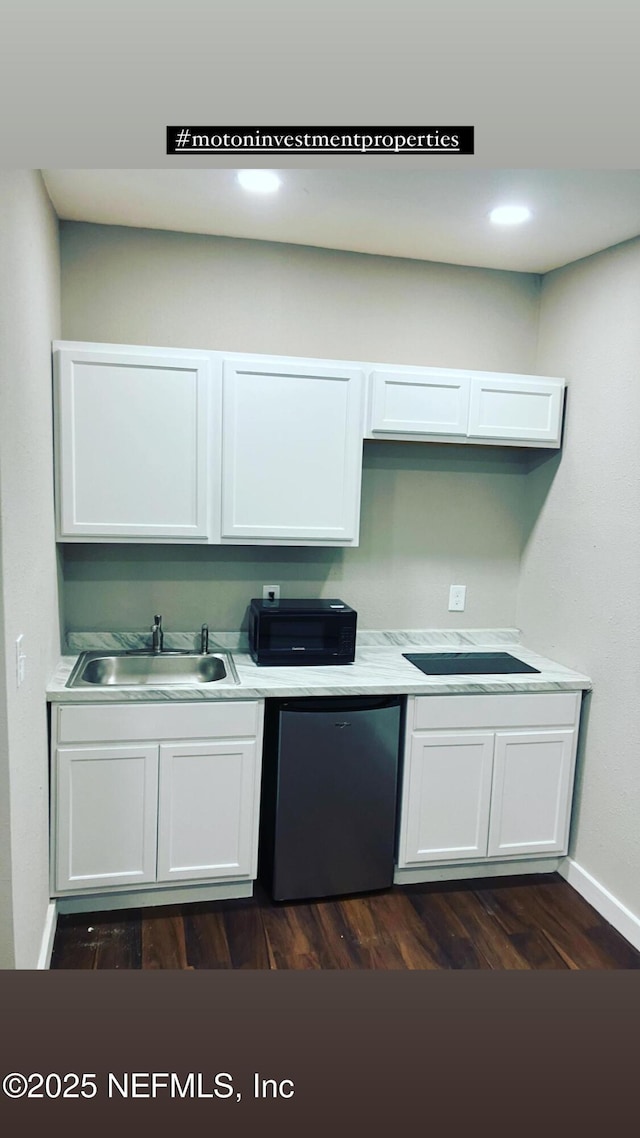 kitchen featuring dishwasher, light countertops, white cabinetry, and a sink