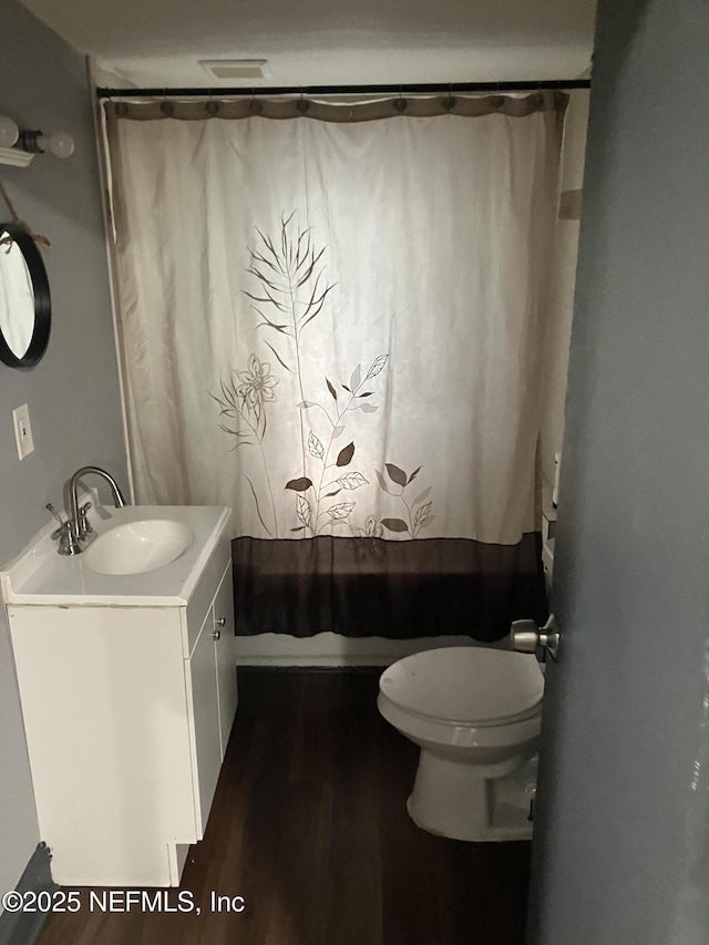 bathroom featuring toilet, vanity, a shower with shower curtain, and wood finished floors