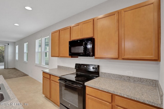 kitchen with a wealth of natural light, black appliances, recessed lighting, and light countertops