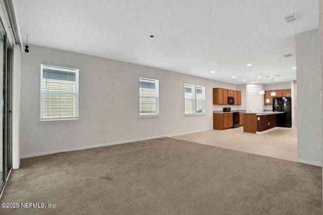 unfurnished living room featuring light carpet, visible vents, recessed lighting, and baseboards