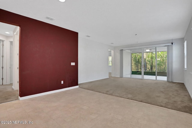 unfurnished living room with visible vents, carpet floors, and baseboards