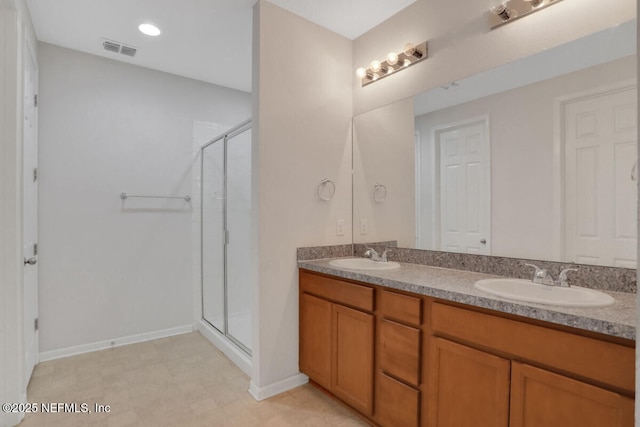 bathroom with a shower stall, double vanity, visible vents, and a sink