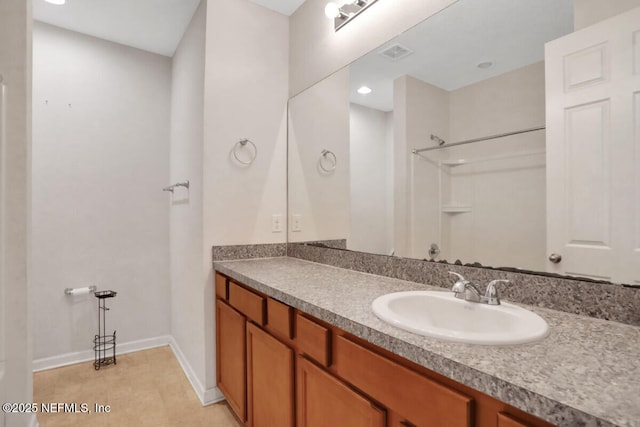 full bathroom featuring baseboards, visible vents, vanity, and walk in shower