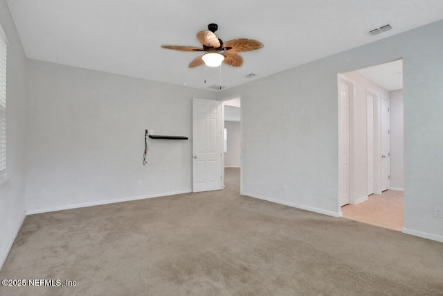 unfurnished room featuring carpet, a ceiling fan, visible vents, and baseboards