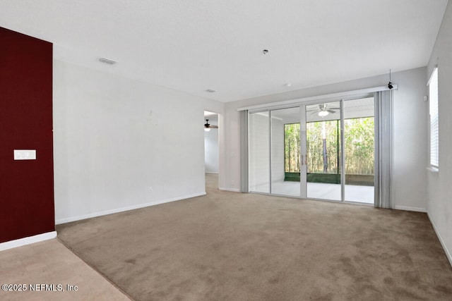 spare room featuring baseboards, carpet floors, and ceiling fan