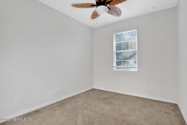 carpeted empty room with baseboards and a ceiling fan