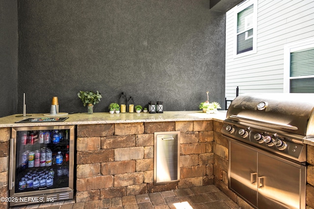 view of patio featuring a grill, an outdoor kitchen, and beverage cooler