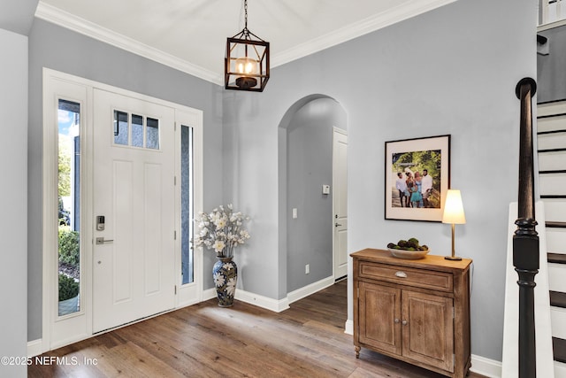 entryway featuring arched walkways, wood finished floors, and crown molding