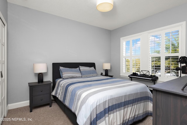 bedroom with baseboards and light colored carpet
