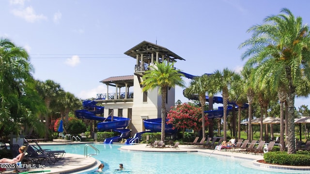 pool featuring a water slide and a patio area