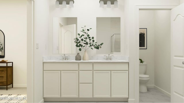 full bathroom featuring double vanity, toilet, baseboards, and a sink