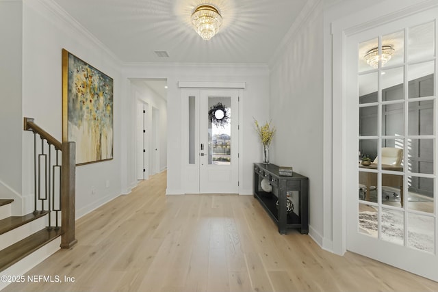 entrance foyer featuring a notable chandelier, light wood-style flooring, ornamental molding, baseboards, and stairs